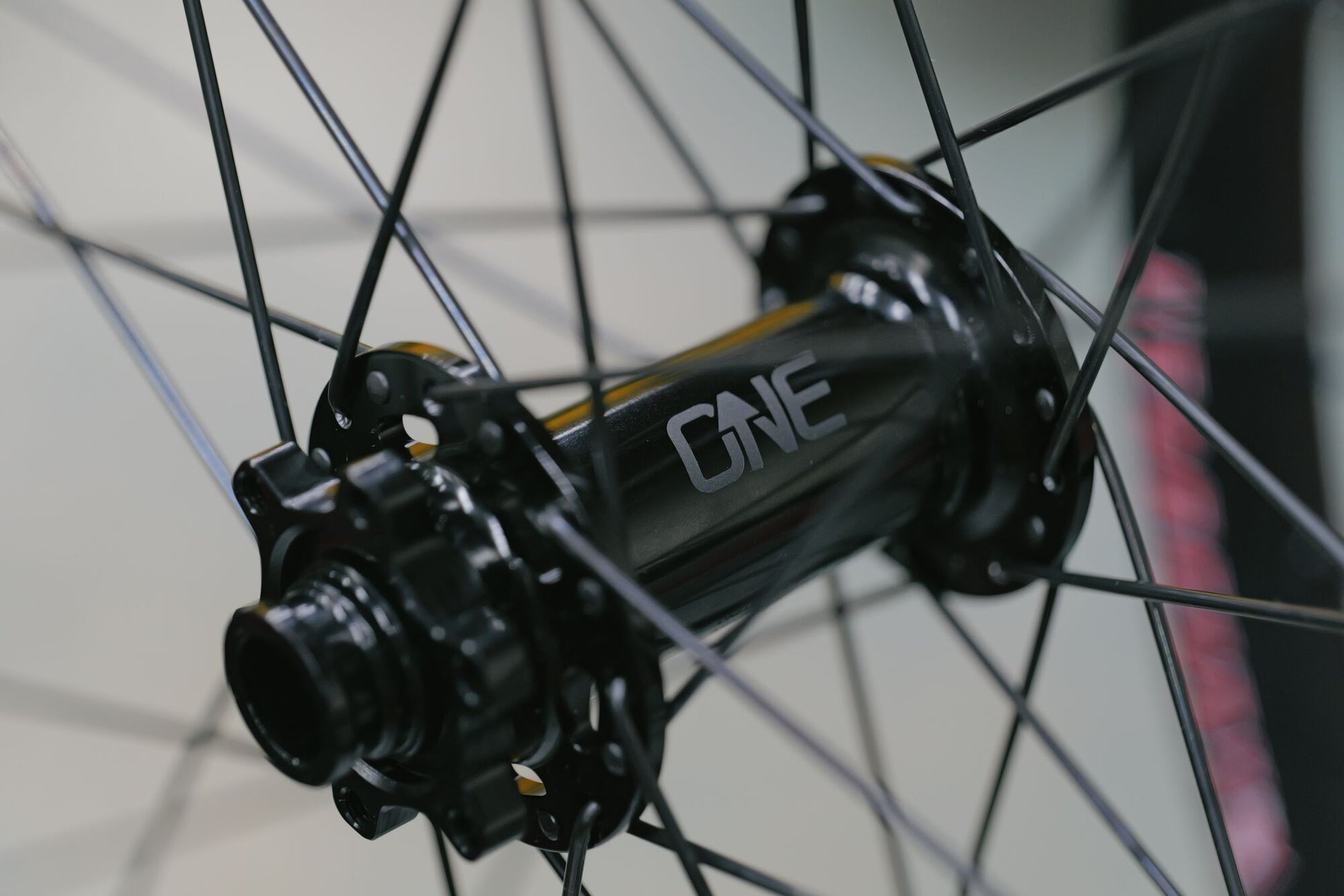 Close-up of a bicycle hub with 'ONE' branding on a blurred background